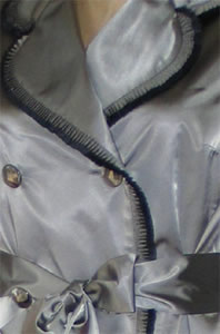 close up view of couture pleat detail and glass faceted buttons