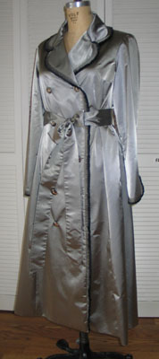 Irridescent Silver Raincoat, double breasted, features couture pleating around lapel to hem. Pleating created from the selvage edge of fabric.